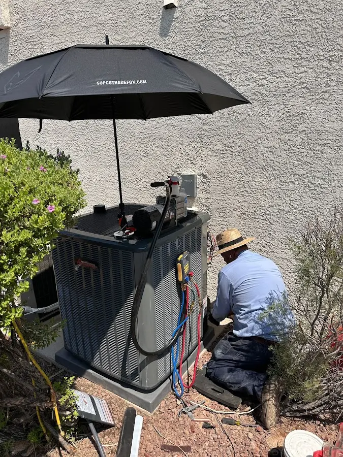 HVAC technician performing outdoor AC maintenance in Pitman